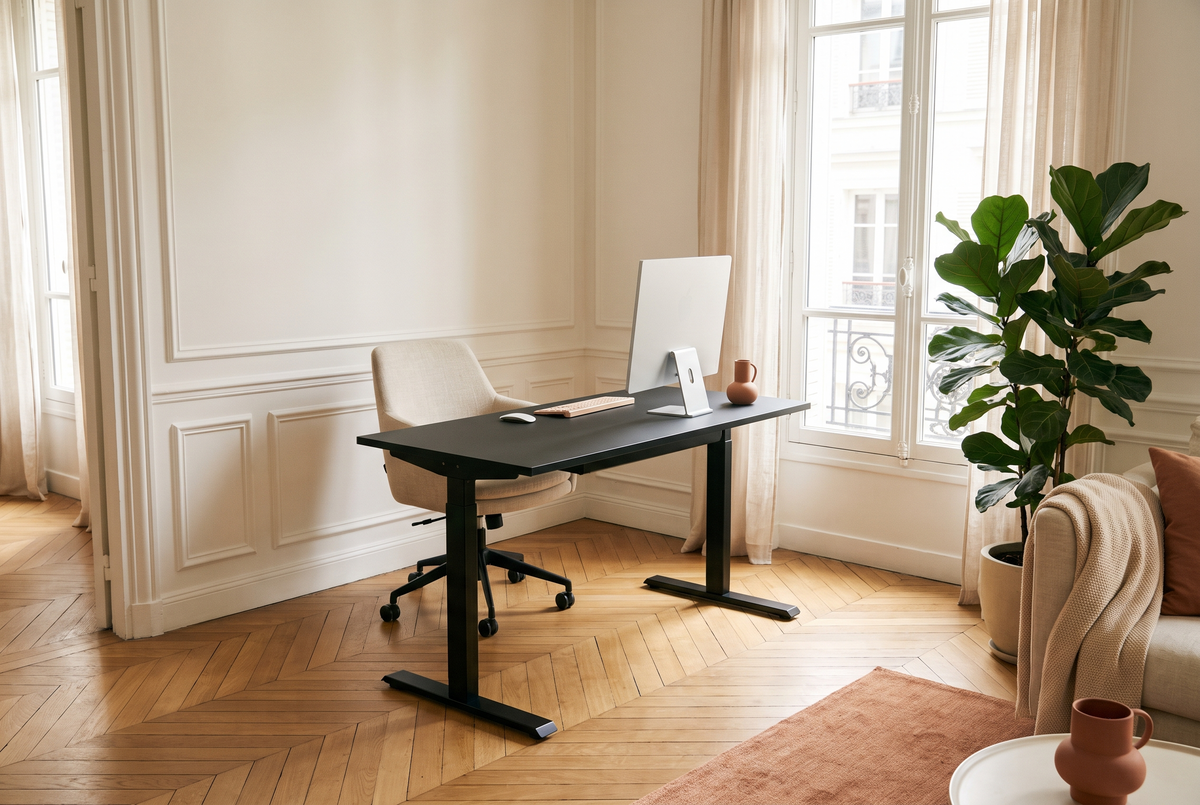 Bureau assis-debout Relève Un dans un salon lumineux